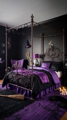 a purple and black bedroom with an iron bed frame in the middle, along with candles on the floor