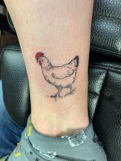 a small chicken tattoo on the ankle