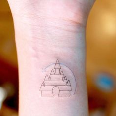 a small wrist tattoo with a castle on it