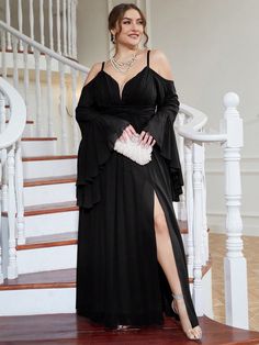 a woman in a black dress standing on stairs