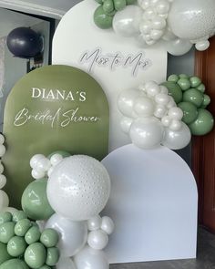 balloons and decorations for a bridal shower at the entrance to a wedding reception in green and white