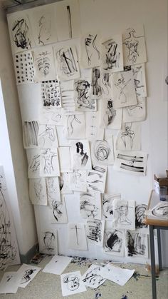 many drawings are hanging on the wall in an art studio