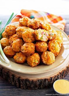 a white plate topped with tater tots next to dipping sauce