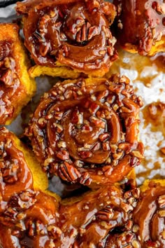 several cinnamon rolls with pecans and caramel drizzled on the top