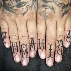 two hands with tattoos on their fingers and one has the word love written in cursive writing