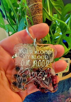 someone holding up a keychain that says, our blood my blood our blood