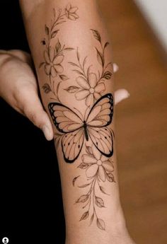 a woman's arm with a butterfly tattoo on it