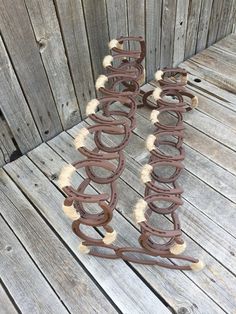 two pieces of metal sitting on top of a wooden floor next to a fence and wood planks