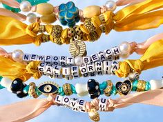 several bracelets with words and charms attached to each other in front of a blue sky