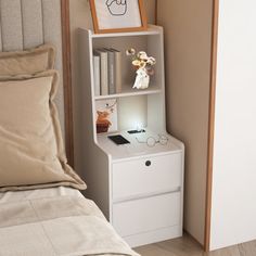 a bed with a white book shelf next to a night stand on top of it