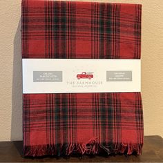 a red plaid blanket sitting on top of a wooden table