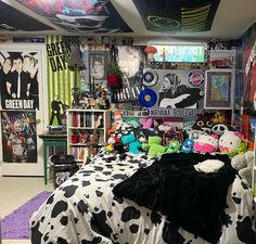 a bed room filled with lots of stuffed animals and posters on the wall above it