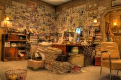 a room filled with lots of clutter next to a wall covered in pictures and papers