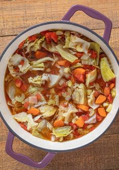 a pot filled with soup on top of a wooden table