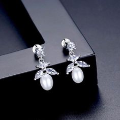 Delicate and elegant, this pair of bridal earrings features iridescent white pearls and clear cubic zirconia that capture the light from every angle with a perfectly translucent appeal. The earrings are rhodium plated for a bright finish which enhances the intricate detailing and conveys a modern take on old elegance. Overall length of the earrings is 0.78" (approx. 2cm) long and come with sturdy backs. The size of pearls is 6-7mm. Can make a thoughtful Bridesmaids gift that will be both a weddi Pearl White Cubic Zirconia Pearl Earrings For Evening, White Pearl Drop Crystal Earrings In Cubic Zirconia, White Cubic Zirconia Pearl Earrings With Sparkling Stones, White Cubic Zirconia Earrings With Sparkling Stones, White Crystal Pearl Earrings For Formal Occasions, Formal White Crystal Pearl Earrings, White Pearl Drop Earrings In Cubic Zirconia, Cubic Zirconia Drop Earrings With Sparkling Stones, Sparkling White Pearl Earrings For Formal Occasions