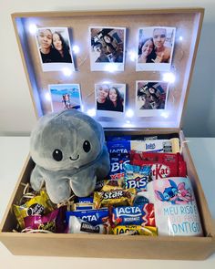 a stuffed animal in a wooden box filled with candy and candies, surrounded by photos