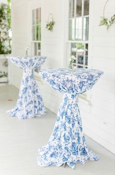 two blue and white pedestals with flowers on them