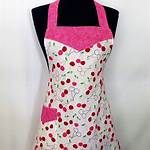 an apron with pink trim on the front and white, polka dot design on the back