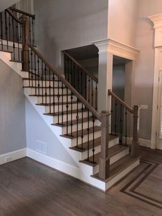 a staircase with white railing and wood handrails