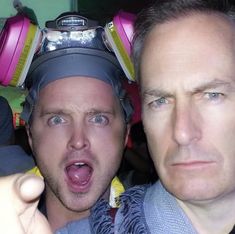 two men with headphones on their heads taking a selfie in front of the camera