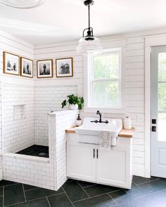 a white bathroom with black and white tile flooring