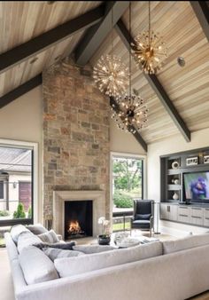 a living room filled with furniture and a flat screen tv mounted on a wall next to a fire place