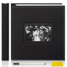 a black leather photo album with a yellow pen next to it and an image of a bride and groom