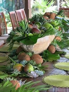 the table is set with many different types of plants and fruit in bowls on it