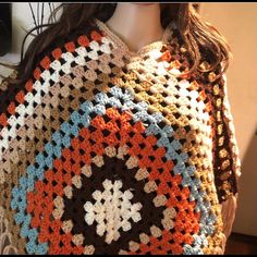 a crocheted granny shawl is displayed on a mannequin's head