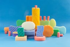 several different types of soaps and sponges on a blue background