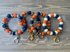 These gorgeous silicone beaded wristlets keyrings are both stylish and functional! Choose from 4 different animals prints (cow, white leopard, cream leopard, and gold leopard) paired with orange and navy blue beads. Add on a customizable charm with your name, initials, etc.: https://www.etsy.com/listing/1244223320/customizable-glitter-charm-for-wristlets?click_key=3363924c6a79a322d191fe87312d4ce011b4b0da%3A1244223320&click_sum=f84419a3&ref=shop_home_active_1 Whether you are a teacher, mama on th Bead Keychain, Home Ac, Keychain Wristlet, Beadable Products, White Leopard, Auburn Tigers