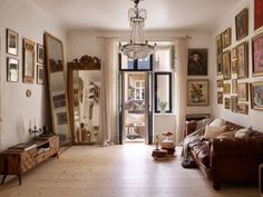 a living room filled with furniture and lots of pictures on the wall next to a doorway