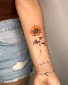 a woman's arm with a sunflower tattoo on it