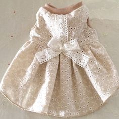 a white dress with a bow on the front and back, sitting on top of a table