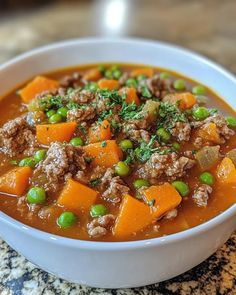 a white bowl filled with meat and vegetables