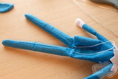 a pair of scissors are laying on the table next to a blue doll's head