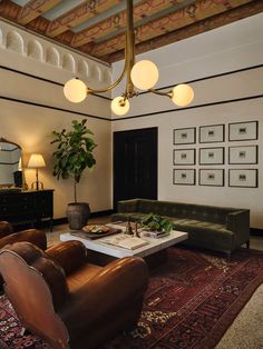 a living room with couches, tables and pictures hanging on the wall above them