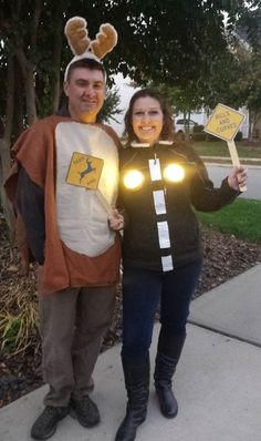 a man and woman dressed up in costumes standing next to each other on the sidewalk