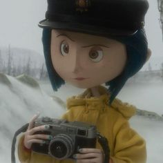 a doll holding a camera in the snow