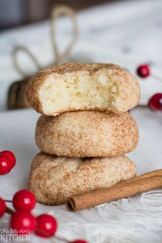 three cinnamon sugar donuts stacked on top of each other next to a cinnamon stick