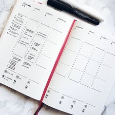 an open planner with a pen on top of it