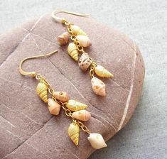 The sea has so much to give! After the sea urchin collection we wanted to show more of the possibilities coming from the sea. These earrings are made with 24kr gold plated shells, earwires and chain and real shell between them. An elegant and wonderful result! Very comfortable and light weighted. More sea treasures coming up, and we will gladly make the custom order to your wishes and dreams with sea treasures! The earrings are 2 3/4'' (7 cm) including the wires. All metal is gold plated (24kr), nickel and lead free. Will be sent by registered airmail. More sea treasures coming up, and we will gladly make the custom order to your wishes and dreams with sea treasures! Two shipping options: Registered airmail takes 15 - 30 days on average,it is cheap and safe but slow. TNT which takes 5-7 da Sea Treasure, Seashell Beach, Earrings Beach, Seashell Earrings, Beach Earrings, Golden Beach, Sea Urchin, Cluster Earrings, Sea Shells