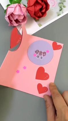 someone is making a card with hearts and flowers on the table next to it that says happy valentine's day