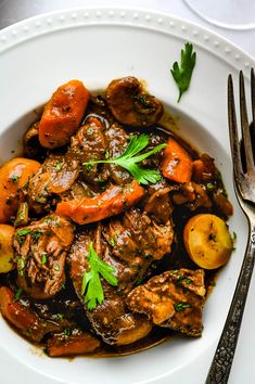 a white bowl filled with meat and vegetables