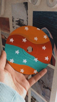 a person holding up a wooden disc with stars on it