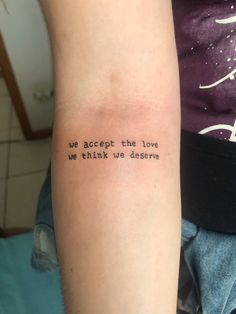 a person with a tattoo on their arm that says, we accept the love we think we