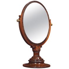 an old fashioned wooden mirror on a stand