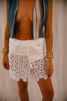 Upcycled Vintage French Crochet and Lace Patchwork Shorts – Handmade by Vagabond Ibiza These upcycled crochet shorts, crafted from vintage French crochet and lace panels, are an exquisite example of sustainable fashion. Carefully patchworked together in our Vagabond Ibiza studio, the lace and crochet elements create a striking new textile. The intricate detailing and delicate textures make these shorts a standout piece for summer or festival wear. Designed in a small size, the shorts fit the model, a UK size 8, comfortably. The combination of lace and crochet adds an elegant, feminine touch to the modern silhouette. • Material: Upcycled vintage French crochet and lace panels • Size: Small (Model is UK size 8) • Design: Patchwork design with intricate lace and crochet detailing • Details: H Fitted Crochet Lace Bottoms For Beach, White Crochet Lace Bottoms For Vacation, Bohemian Shorts With Crochet Trim, Bohemian Style Shorts With Crochet Trim For Summer, White Lace Beachwear Bottoms, Fitted Lace Beachwear Bottoms, Bohemian Bottoms With Crochet Trim For Summer, Bohemian Shorts With Crochet Trim For Vacation, Bohemian Summer Bottoms With Crochet Trim