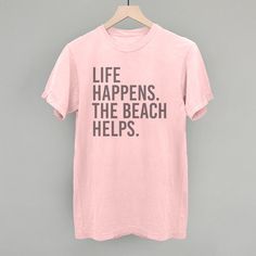 Life Happens. The Beach Helps. Beach Holiday Graphic Print T-shirt, Graphic Print T-shirt For Beach Holiday, Beach Holiday Cotton T-shirt, Beach Season Holiday Cotton T-shirt, Pink Graphic Print T-shirt For Holiday, Cotton T-shirt For Beach Holiday, Letter Print T-shirt For Beach Season Holiday, Fun Beach Season T-shirt With Text Print, Beach Season Graphic Tee With Text Print