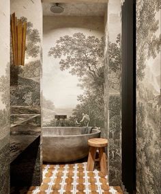 a bath room with a large tub and wallpaper on the walls, along with a stool